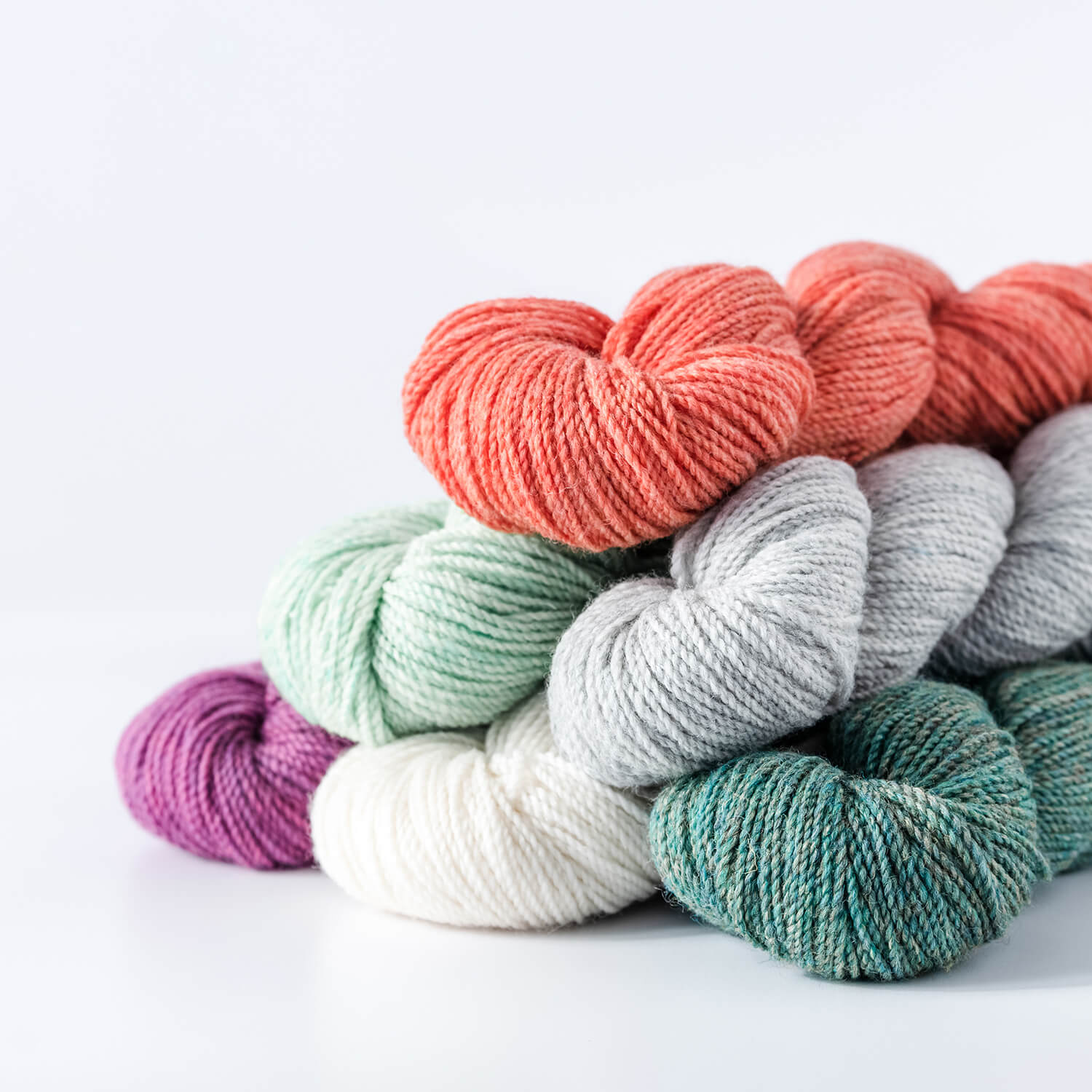 a pile of several hanks of Camper yarn in a variety of colors